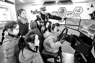 山東省榮成市公安局道路交通安全宣傳教育基地，交警帶領(lǐng)小學(xué)生現(xiàn)場(chǎng)體驗(yàn)?zāi)M駕駛。新華社發(fā)